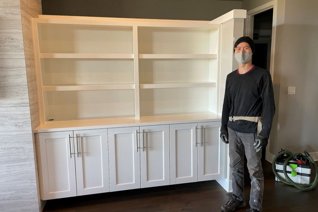 Me standing next to painted and installed shelving
